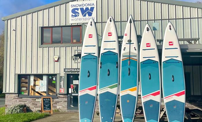 Picture of Snowdonia Watersports shop with a row of paddleboards on display.